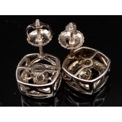 106 - A 10K white gold pair of diamond earrings with moving parts. made in USA with original box.