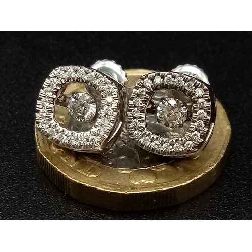 106 - A 10K white gold pair of diamond earrings with moving parts. made in USA with original box.