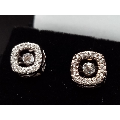 106 - A 10K white gold pair of diamond earrings with moving parts. made in USA with original box.