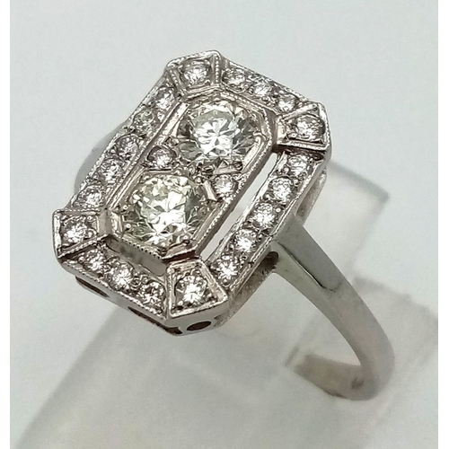 1083 - An Art Deco platinum ring with two beautiful brilliant cut diamonds surrounded by a halo of diamonds... 