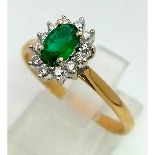 134 - An 18K yellow gold ring with an oval cut emerald surrounded bya halo of diamonds. ring size: S, weig... 