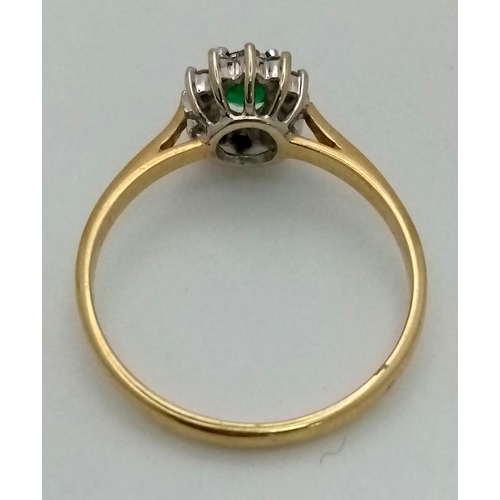 134 - An 18K yellow gold ring with an oval cut emerald surrounded bya halo of diamonds. ring size: S, weig... 