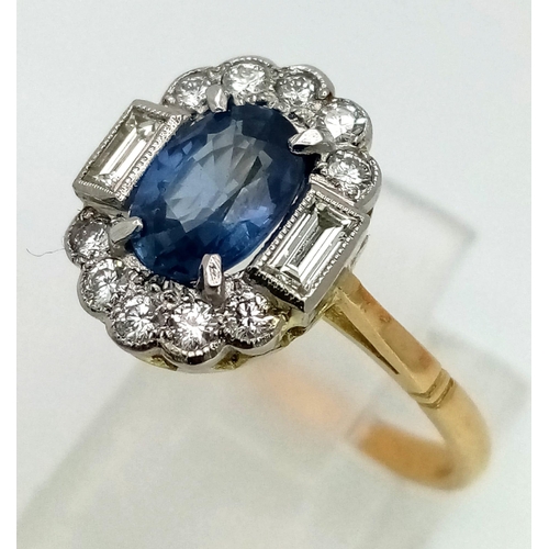 763 - An 18K yellow gold ring with a blue, oval cut sapphire, surrounded by round and baguette cut diamond... 