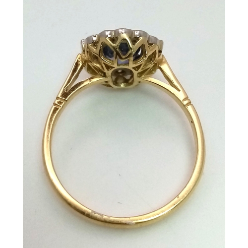 763 - An 18K yellow gold ring with a blue, oval cut sapphire, surrounded by round and baguette cut diamond... 