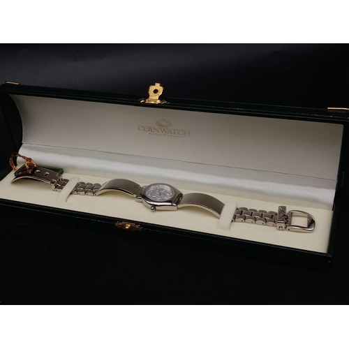 335 - A ladies COIN WATCH in original presentation box. 25 mm case, stainless steel construction, in new/u... 