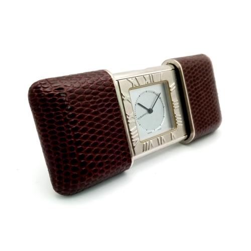 636 - A stylish TIFFANY & Co travel clock in a lizard leather case. 
Dimensions: 55 x 38 x 13 mm (closed).