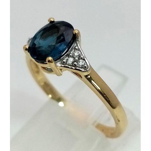 1060 - A 10K Yellow Gold Blue Topaz and Diamond Ring. Central oval topaz with diamonds on shoulders. Size R... 