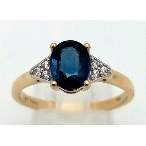 1060 - A 10K Yellow Gold Blue Topaz and Diamond Ring. Central oval topaz with diamonds on shoulders. Size R... 