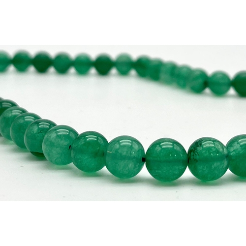 1390 - A Pale Green Jade Bead Necklace with Silver Clasp. 8mm.
52cm.