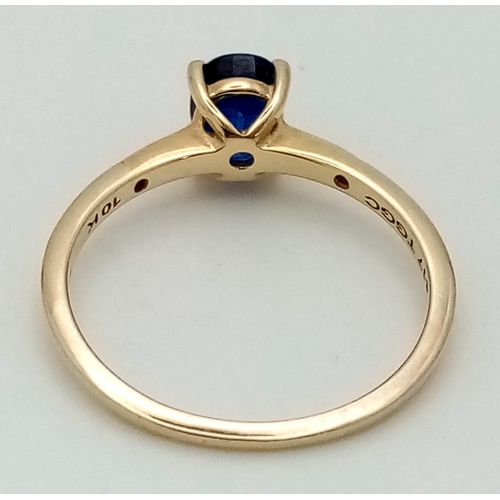 1497 - A 10K Yellow Gold Sapphire and Diamond Ring. Central oval sapphire with a small diamond either side.... 