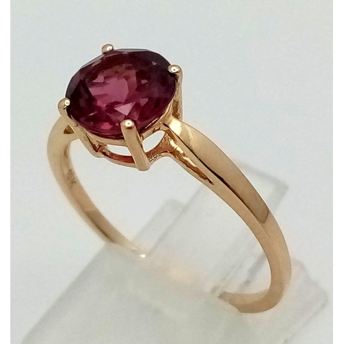 1499 - A 10K Yellow Gold Pink Tourmaline Ring. Central round cut tourmaline. Size R. Total weight - 2.1g