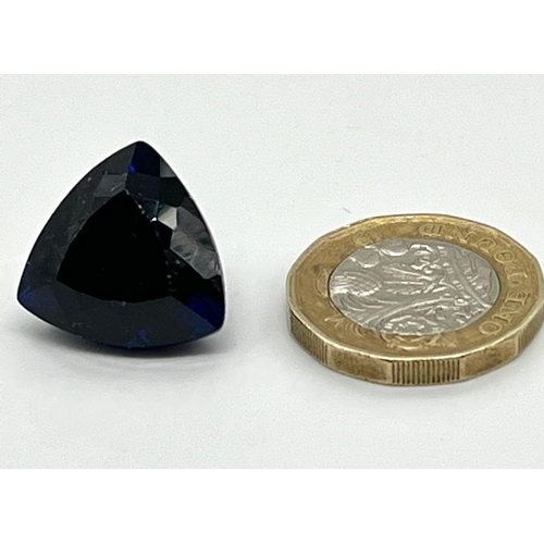 1288 - A 28ct Dark Blue Gemstone. Trillion shape with no visible inclusions. 18 x 18 x 13mm. Heat treated. ... 