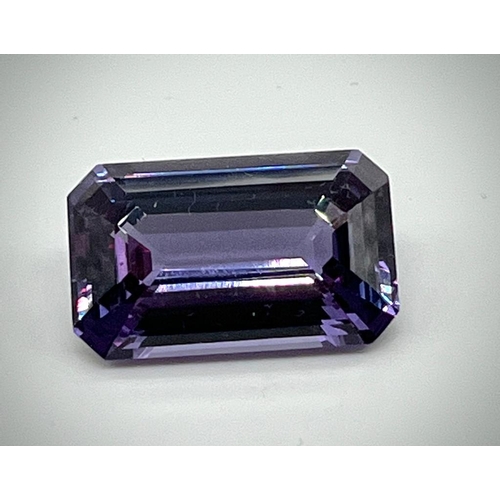 732 - A 32ct Purple/Blue Gemstone. Emerald cut with no visible inclusions. 23 x 14 x 9mm. Heat treated. No... 