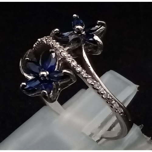 909 - An 18K White Gold Diamond and Sapphire Floral Burst Ring. 3.35g total weight. Size M/N.