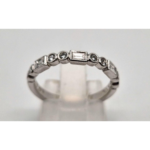 407 - A fine 9K white gold half eternity ring with round cut and baguette diamonds. Ring size: M1/2, weigh... 