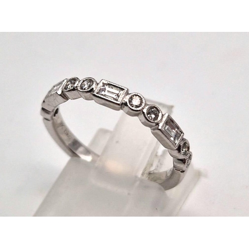 407 - A fine 9K white gold half eternity ring with round cut and baguette diamonds. Ring size: M1/2, weigh... 