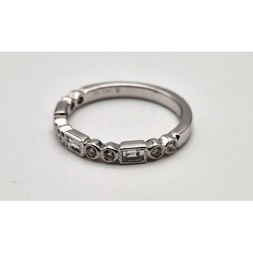 407 - A fine 9K white gold half eternity ring with round cut and baguette diamonds. Ring size: M1/2, weigh... 