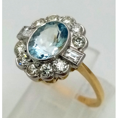 615 - A gorgeous 18K gold ring with a large, oval cut aquamarine, surrounded by a halo of round cut diamon... 