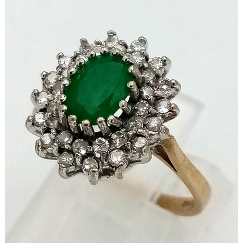 622 - A vintage, 9k yellow gold ring with a central oval cut emerald (1 carat appr.), surrounded by a doub... 