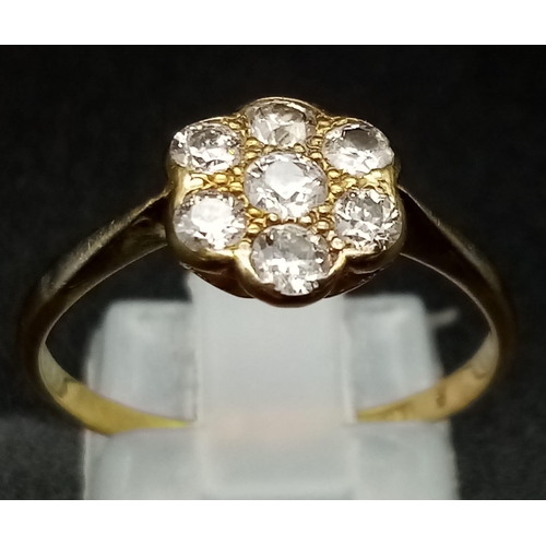 103 - An Edwardian 18K Yellow Gold and Platinum Diamond Cluster Ring. Seven bright-white round diamonds cr... 