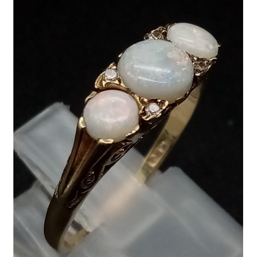 305 - An Antique 9K Yellow Gold Opal and Diamond Ring. Three opals and four diamonds set in scroll decorat... 