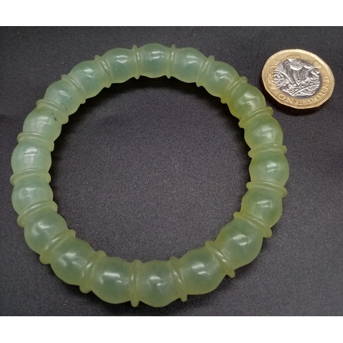 953 - An Antique Chinese Pale Celadon Jade Bangle. Ball-ridge design. 6cm inner diameter.