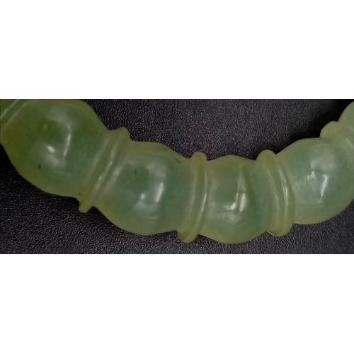 953 - An Antique Chinese Pale Celadon Jade Bangle. Ball-ridge design. 6cm inner diameter.