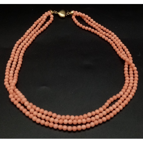 974 - A Vintage Three-Strand Red Coral Beaded Necklace with an 18k yellow gold heart clasp. 38 - 44cm. Tot... 