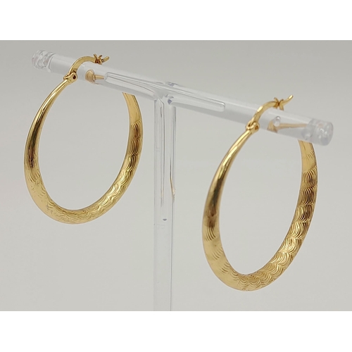 1059 - A large pair of gold tone hoop earrings. Diameter: 4 cm, weight: 7.4 g.