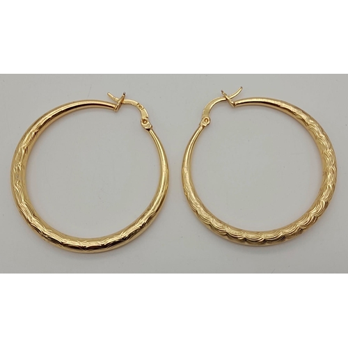 1059 - A large pair of gold tone hoop earrings. Diameter: 4 cm, weight: 7.4 g.