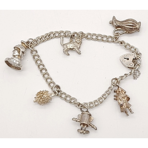 1496 - A Vintage Child's 925 Silver Charm Bracelet with Heart Clasp. Six charms. 18g total weight.