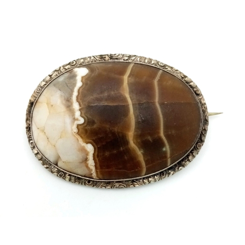 730 - An Antique Celtic Silver and Hardstone Brooch Set with a Natural Calcite Cabochon. 5.5cm Length