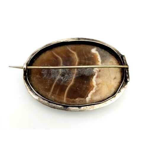 730 - An Antique Celtic Silver and Hardstone Brooch Set with a Natural Calcite Cabochon. 5.5cm Length