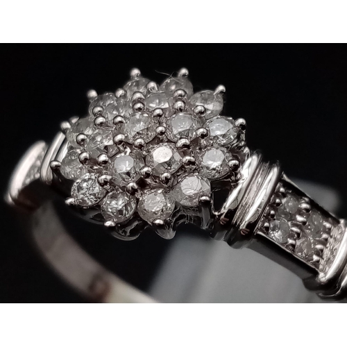 283 - A 9K white gold ring with a cluster of diamonds and further diamonds on shoulders (diamonds 0.30 car... 