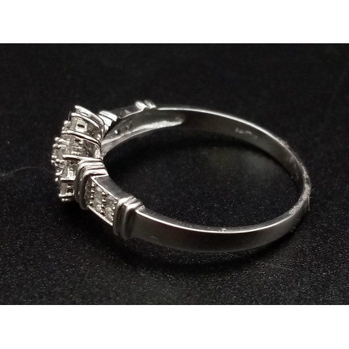 283 - A 9K white gold ring with a cluster of diamonds and further diamonds on shoulders (diamonds 0.30 car... 