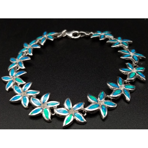 828 - A sterling silver lot including a bracelet with synthetic blue opal flowers, a ring with cubic zirco... 