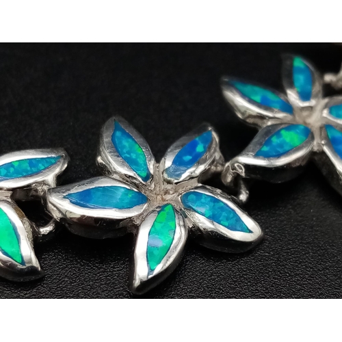 828 - A sterling silver lot including a bracelet with synthetic blue opal flowers, a ring with cubic zirco... 