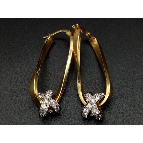 1025 - A 9K yellow gold pair of twisted earrings with cubic zirconia. Height: 33 mm, weight: 3.43 g.