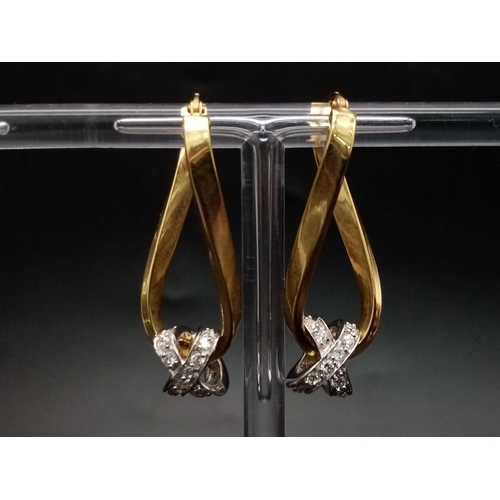 1025 - A 9K yellow gold pair of twisted earrings with cubic zirconia. Height: 33 mm, weight: 3.43 g.