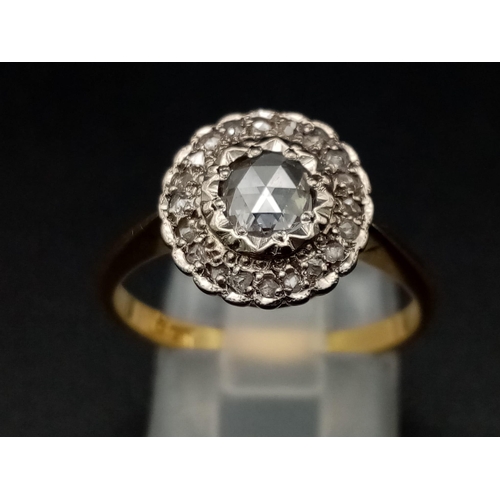 1054 - A vintage 18K yellow gold ring with a large rose cut diamond surrounded by a halo of diamonds. Ring ... 