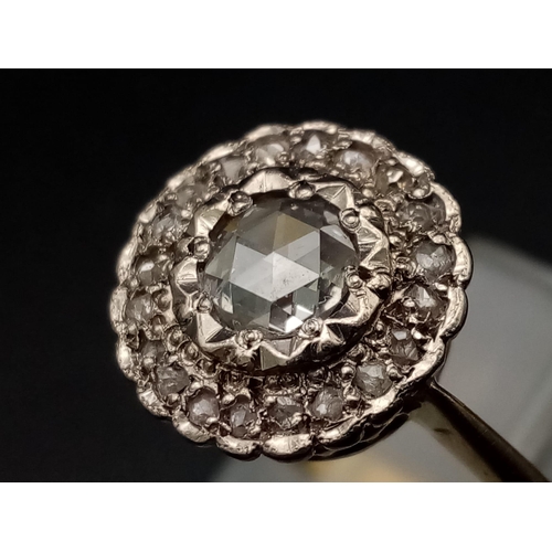 1054 - A vintage 18K yellow gold ring with a large rose cut diamond surrounded by a halo of diamonds. Ring ... 