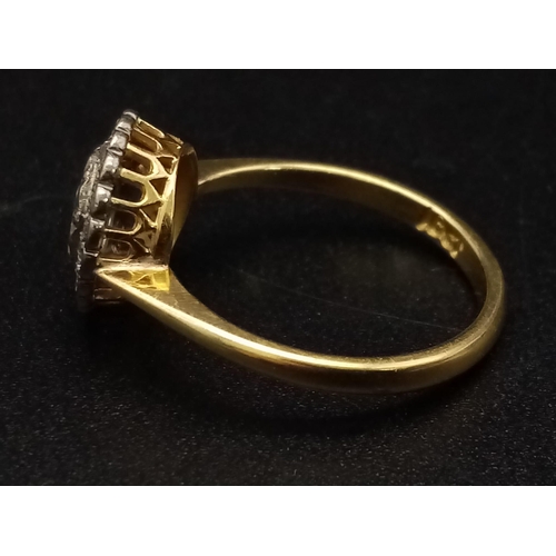 1054 - A vintage 18K yellow gold ring with a large rose cut diamond surrounded by a halo of diamonds. Ring ... 