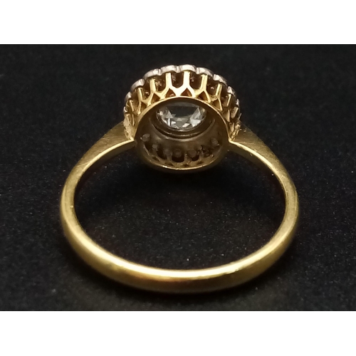 1054 - A vintage 18K yellow gold ring with a large rose cut diamond surrounded by a halo of diamonds. Ring ... 