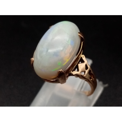 1068 - A vintage, 9K yellow gold ring with an Australian large opal cabochon, exhibiting good iridescence. ... 