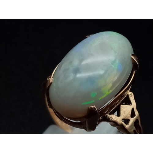 1068 - A vintage, 9K yellow gold ring with an Australian large opal cabochon, exhibiting good iridescence. ... 