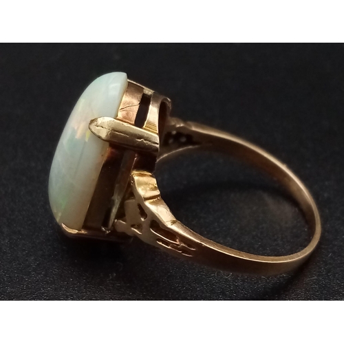 1068 - A vintage, 9K yellow gold ring with an Australian large opal cabochon, exhibiting good iridescence. ... 