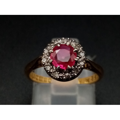 1261 - An 18K yellow gold ring with a round cut ruby surrounded by a halo of diamonds. Ring size: J1/2, wei... 