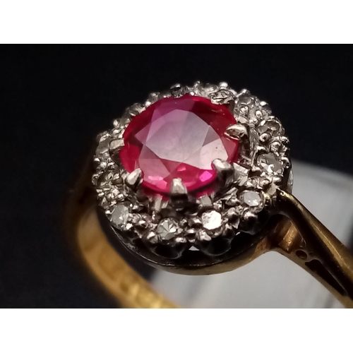 1261 - An 18K yellow gold ring with a round cut ruby surrounded by a halo of diamonds. Ring size: J1/2, wei... 