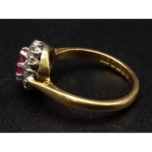 1261 - An 18K yellow gold ring with a round cut ruby surrounded by a halo of diamonds. Ring size: J1/2, wei... 