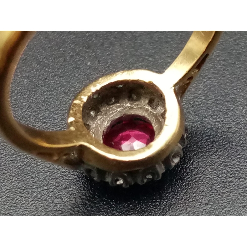 1261 - An 18K yellow gold ring with a round cut ruby surrounded by a halo of diamonds. Ring size: J1/2, wei... 